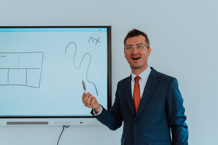 A modernly dressed professor engages in educating students, who listen attentively, creating a dynamic scene of knowledge-sharing and focused learning in the classroom.の写真素材