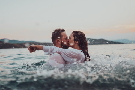 A romantic young couple sharing a passionate kiss amidst the serene beauty of the ocean at sunset.