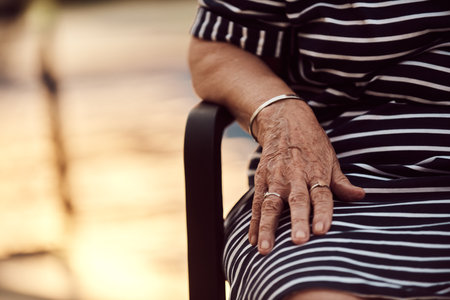 In this close-up photograph, the weathered hand of an elderly woman poignantly captures the essence of aging, the wisdom of years, and the beauty of lifes journeyの写真素材