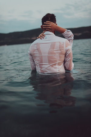 A symbolic and emotionally connected couple tenderly embraces against the backdrop of a serene sea,...