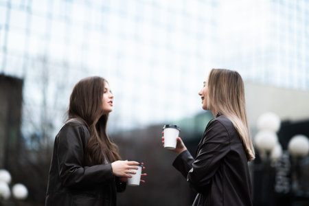 Women Laughing with Coffee Outdoorsの写真素材