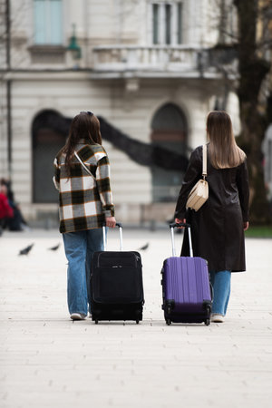 Female Tourists Standing Outdoors with Luggageの写真素材