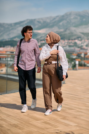 After a day at the office, a man engages in conversation with his colleague wearing a hijab