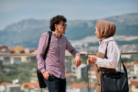 After a day at the office, a business man engages in conversation with his Muslim colleague wearing...