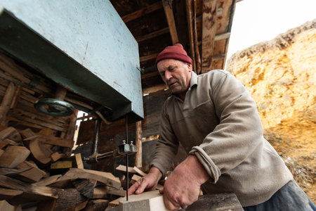 Carpenter Cutting Wood with a Bandsaw in a Rustic Workshop