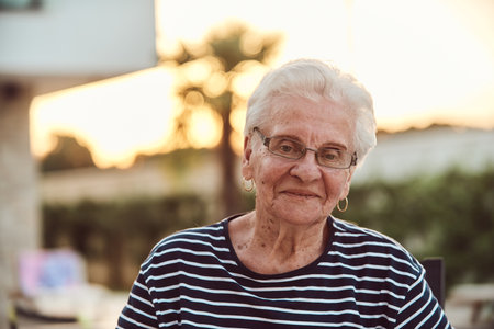 Unfiltered portrait, a real elderly woman sits gracefully in a chair, showcasing the authenticity of...