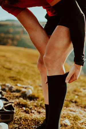 A determined athlete preparing for the start of training on the top of the mountain at sunrise.の写真素材