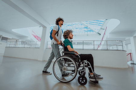 African American student pushing his friends wheelchair through a modern school, demonstrating inclusion, accessibility, and the power of friendship.Assistance to people with disabilitiesの写真素材