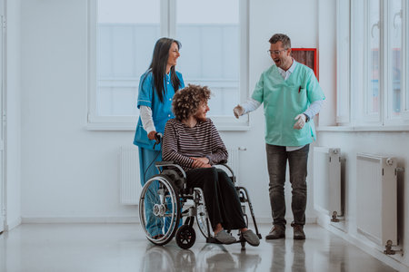 Doctor and a nurse discussing a patients health while the patient, who is in a wheelchair, is...