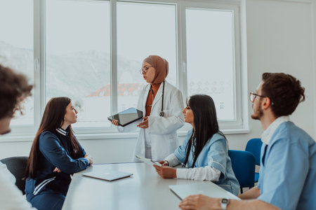 A group of multiethnic medical professionals including doctors, surgeons, and nurses are gathered in a hospital setting discussing patient care and using modern technology to address challenges in the medical field.の写真素材