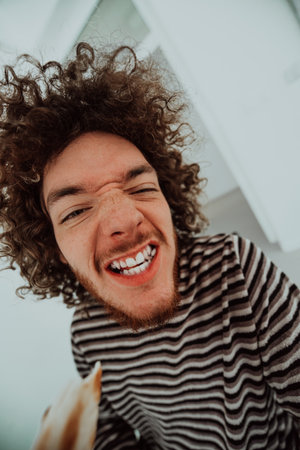 A patient with a funny afro hairstyle brings smiles as they joyfully indulge in a slice of pizza, adding a lighthearted touch to the modern hospital setting, fostering laughter and a positive atmosphere.の写真素材