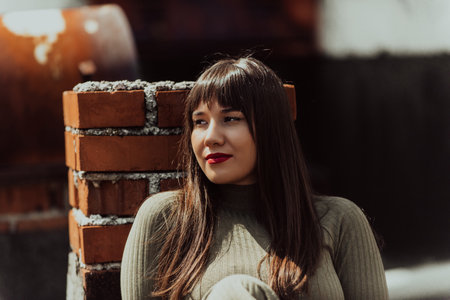 A confident and stylish plus-size woman walking by a modern building in an olive green dress, radiating beauty, empowerment, and self-love.の写真素材