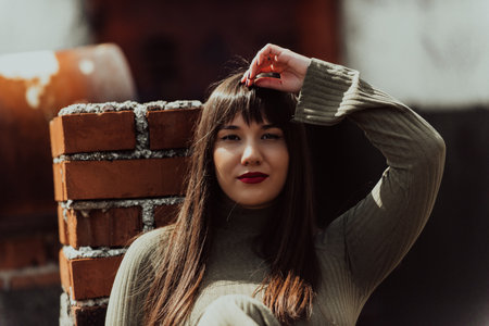 A confident and stylish plus-size woman walking by a modern building in an olive green dress, radiating beauty, empowerment, and self-love.の写真素材