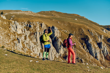 Hikers enjoy a sunny day on a mountain trail overlooking rocky cliffsの写真素材