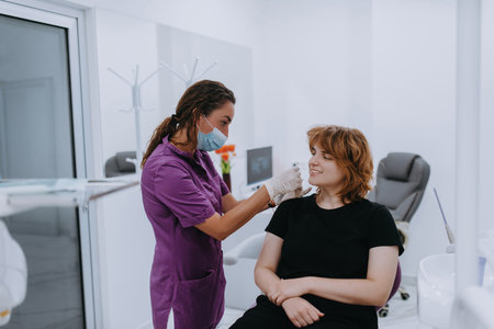 A dentist experimenting with new tooth shades for prosthetics in a dental office, showcasing precision and innovation in dental careの写真素材