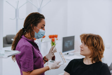 A dentist experimenting with new tooth shades for prosthetics in a dental office, showcasing precision and innovation in dental careの写真素材