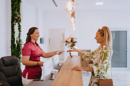 Beautiful blonde shakes hands with an employee of the dental office after the agreed dental examinationの写真素材