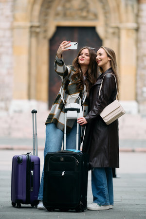 Couple of two female tourists enjoying exploring European cities, concept of tourism and travel, women with suitcases walking around the city, modern lgbt couple of women walking around the cityの写真素材