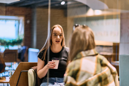 Catching Up and Caffeinating: Two Friends Unwind After a Long Day with Coffee and Conversation