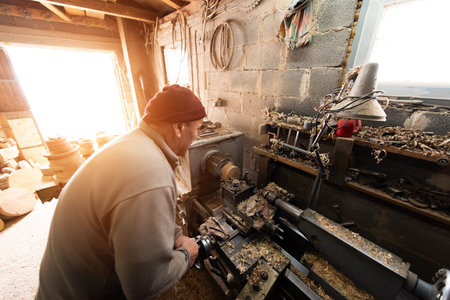 Senior Craftsman Using Wood Lathe Machine in Workshop Woodworking and Carpentry Manual Wood Turning Wood Shavings Craftingの写真素材