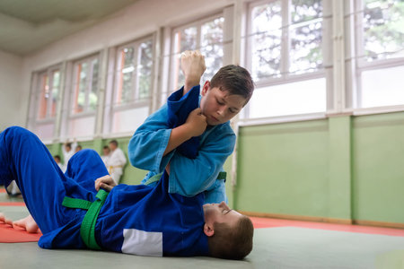 Two young athletes show their judo skills in front of the coaches