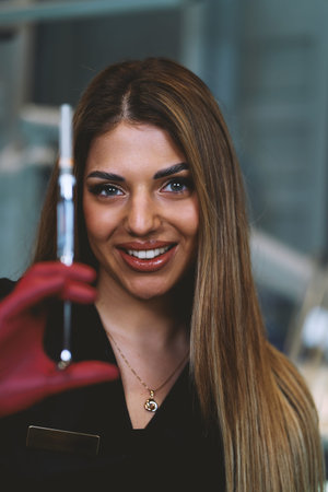 Confident Female Scientist Demonstrates Pipette Technique In Modern Laboratoryの写真素材