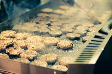 preparing tasty grilled hamburgersの写真素材