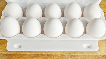 Packing eggs in a box from above and close-up on a wooden boardの写真素材