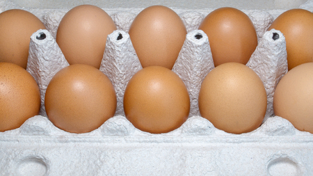 Packing eggs in a cardboard box top and close-up viewの写真素材