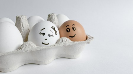 Eggs with funny faces in the package on a white background. Easter Concept Photo. Eggs. Faces on the eggsの写真素材