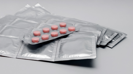 Condoms and pills medicine on a gray background closeupの写真素材
