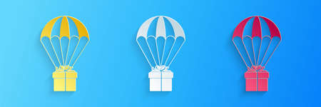 Paper cut Gift box flying on parachute icon isolated on blue background. Delivery service, air shipping concept, bonus concept. Paper art style. Vectorのイラスト素材