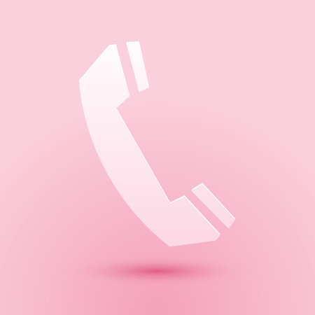 Paper cut Telephone handset icon isolated on pink background. Phone sign. Call support center symbol. Communication technology. Paper art style. Vectorのイラスト素材