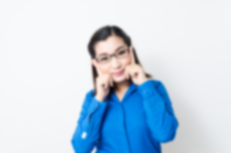 Blur effect of image of a young woman with a lovely look and charming smile in blue shirt