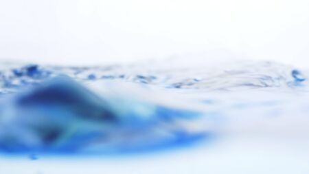 Soft blur focus of Abstract water splash surface filling the frame with the water drop and waving liquid with an air bubble on a white background and copy spaceの写真素材
