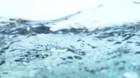 Soft blur focus of Abstract water splash surface filling the frame with the water drop and waving liquid with an air bubble on a white background and copy spaceの写真素材