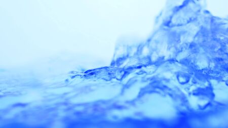 Soft blur focus of Abstract water splash surface filling the frame with the water drop and waving liquid with an air bubble on a white background and copy spaceの写真素材