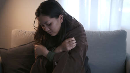 Young Asian woman with a black edge shakes her whole body is about to catch a cold and uses a...