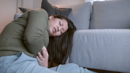 The woman with severe abdominal pain and abdominal pain in her body for unknown reasons lies on the...