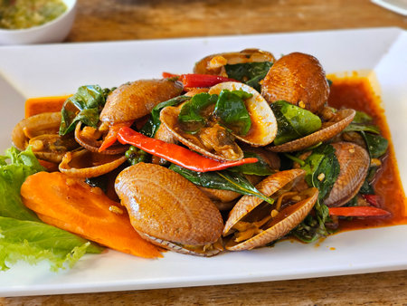 Stir-fried clams dish thai cuisine food photography restaurant setting close-up view culinary delightの写真素材