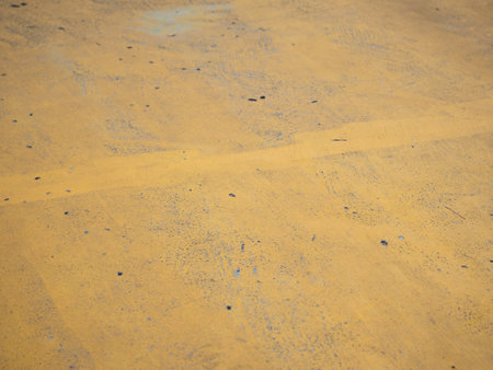 Exploring the textured surface of yellow concrete urban environment abstract imagery ground level perspective artistic expressionの写真素材