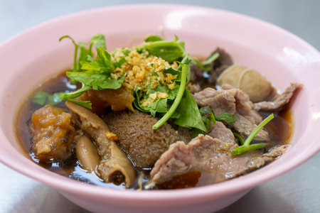 Savory beef noodle soup preparation local eatery culinary art urban setting close-up view comfort...
