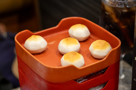 Tasty steamed buns on a red tray restaurant food photography indoor setting close-up culinary delightの写真素材