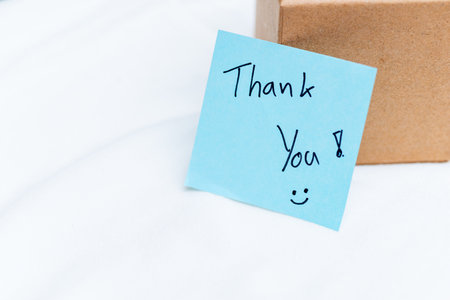 Thank you note on package home office business communication indoor setting close-up perspective gratitude conceptの写真素材