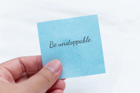 Hand holding note with inspiring text minimalist setting motivational concept uplifting environment...