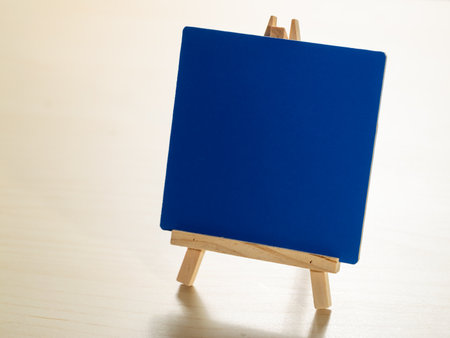 Creative space close-up of artistic blue canvas on mini easel in indoor studioの写真素材