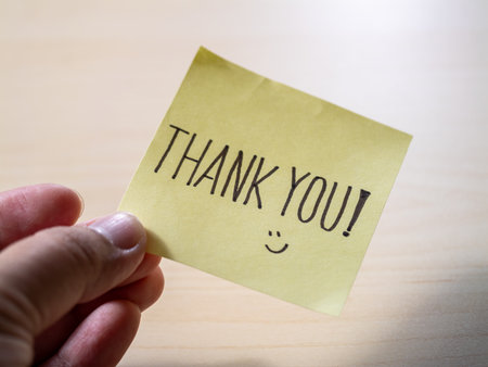 Minimalist office desk close-up handwritten gratitude note with inspirational messageの写真素材