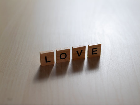 Wooden blocks spell LOVE in a serene environment evoking deep emotional connections.の写真素材