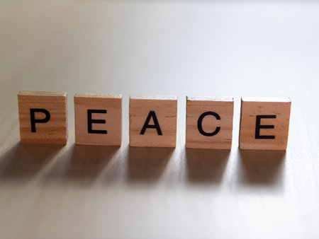 Exploring the theme of peace through wooden letter blocks in a tranquil setting.の写真素材