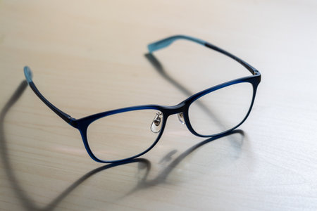 Close-up of stylish eyeglasses on wooden table indoor fashion photography